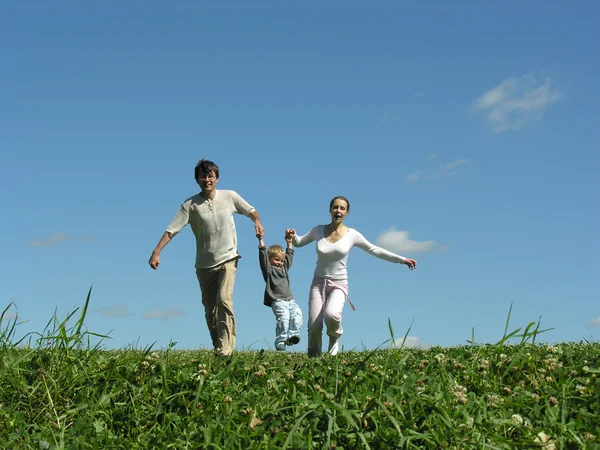 Correndo família com criança no prado — Fotografia de Stock