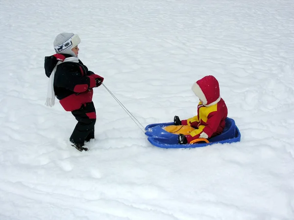 Boy ride baby on sled — Stock Photo, Image