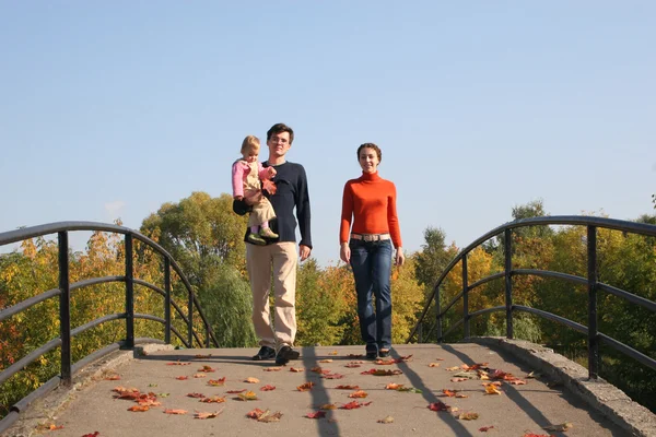 Family with baby on autumn bridge — Stock Photo, Image
