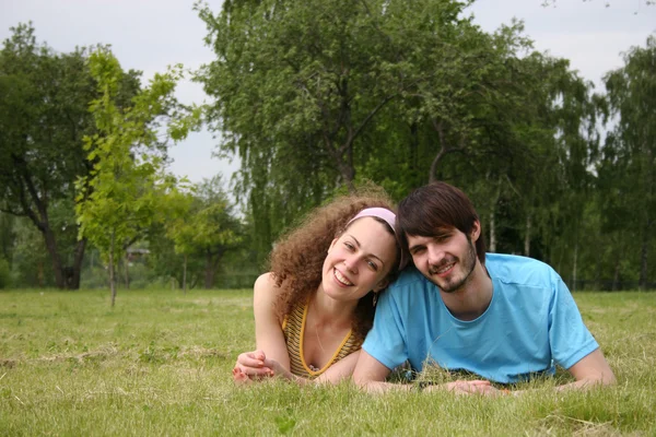 Couple tombant amoureux sur l'herbe — Photo