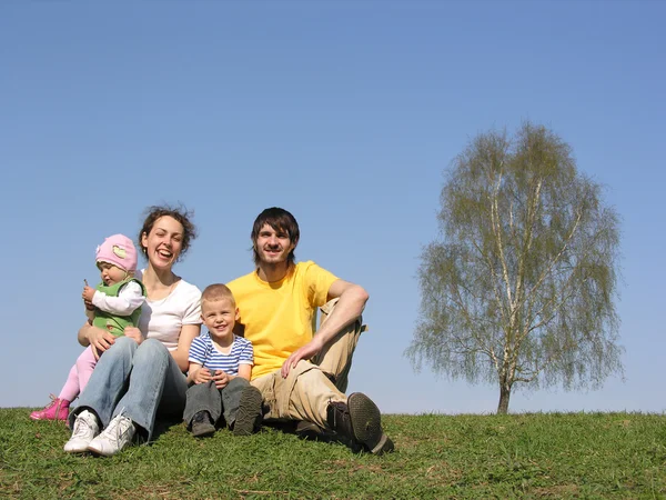 Сидящая семья с двумя детьми. весна . — стоковое фото