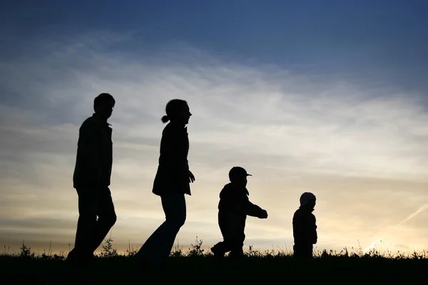 Walking family of four on sky — Stock Photo, Image