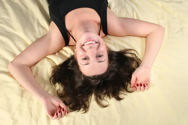 Glad tjej på sängen — Stockfoto