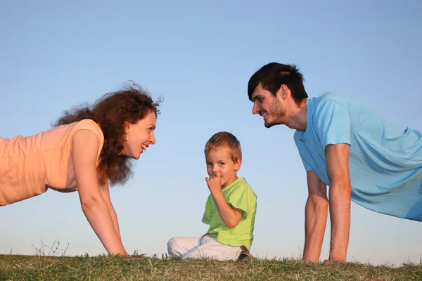 Ребенок и родители на траве — стоковое фото