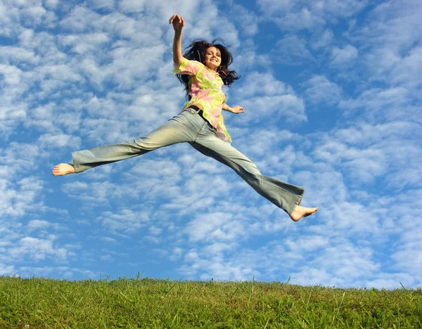 Springen meisje onder wolk hemel — Stockfoto