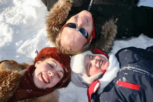 Зимняя семья лежит на снегу — стоковое фото