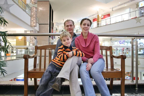 Family on bench in shop — Stock Photo, Image