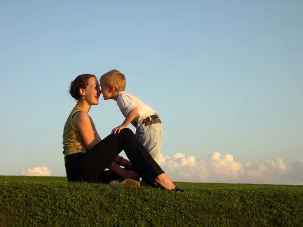 Moeder met zoon op zonsondergang kus door neus — Stockfoto