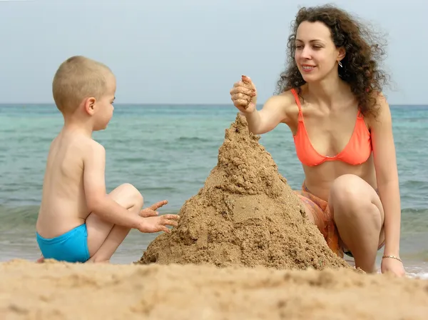 Mamma med son spela på stranden — Stockfoto