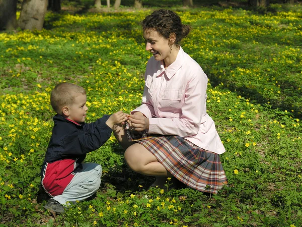 Mamma med son i blomma äng — Stockfoto