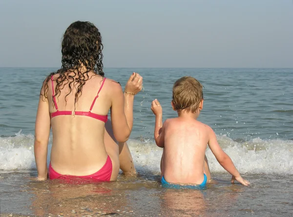 母亲与儿子在海滩上背后 — 图库照片