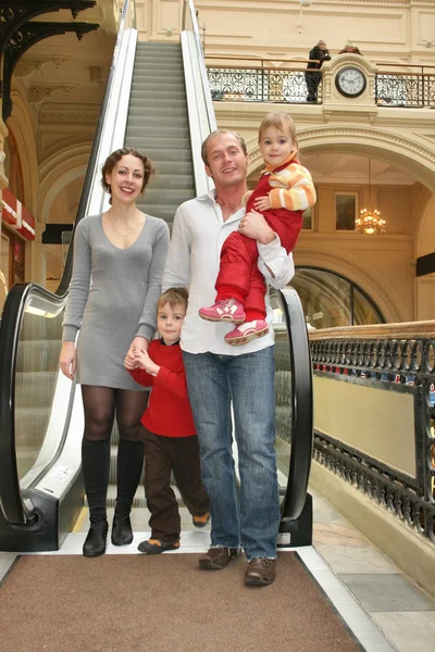 Familie van vier in de winkel en roltrappen — Stockfoto