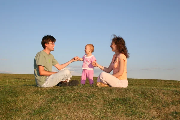 赤ちゃん連れのご家族は草原の上に座る — ストック写真