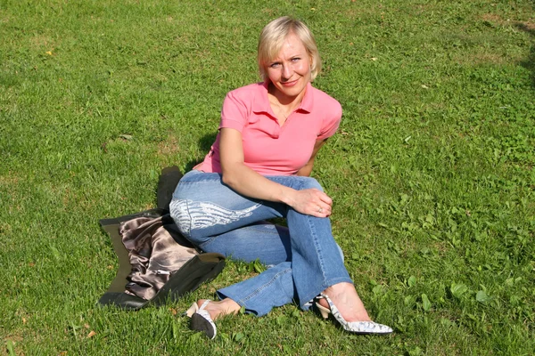 Sarışın bir kadın çimenlerin üzerinde — Stok fotoğraf