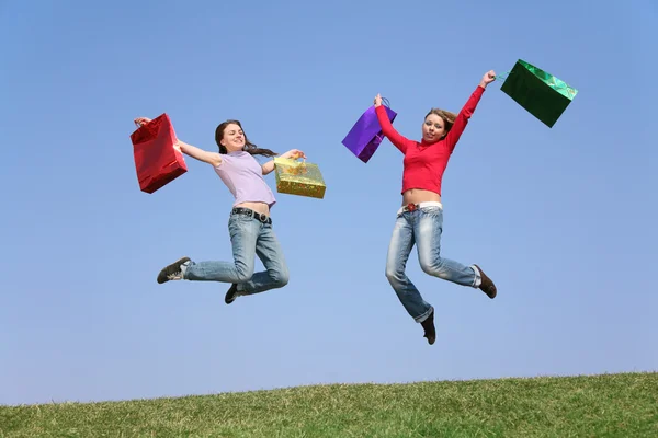 Saltar pareja niñas con bolsas 2 —  Fotos de Stock