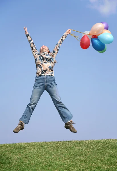 Springen meisje met ballonnen — Stockfoto