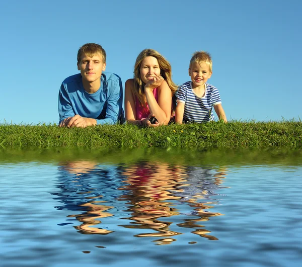 Familie auf Kraut unter blauem Himmel — Stockfoto