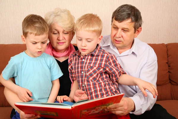 Grootouders met grandcgildren lezen boek — Stockfoto