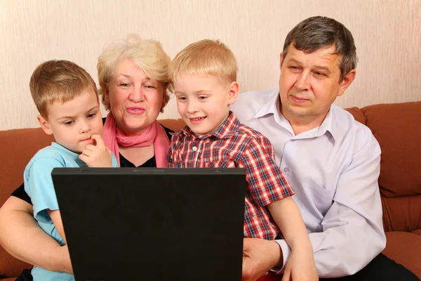 Grandparents with grandchildren with notebook — Stock Photo, Image