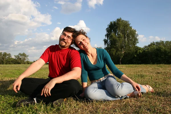 Paar sitzt auf Wiese — Stockfoto