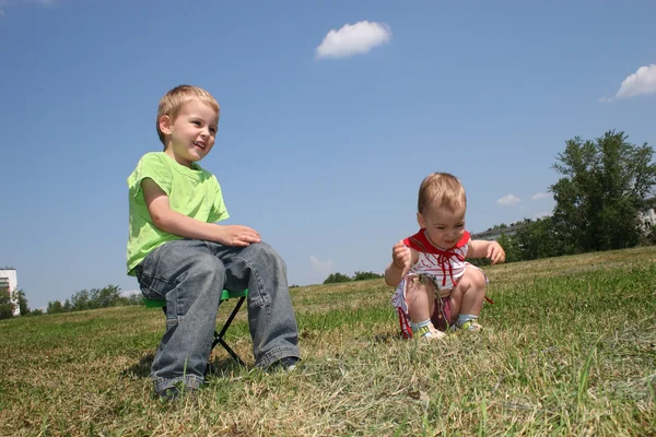 Bebê e criança no prado — Fotografia de Stock