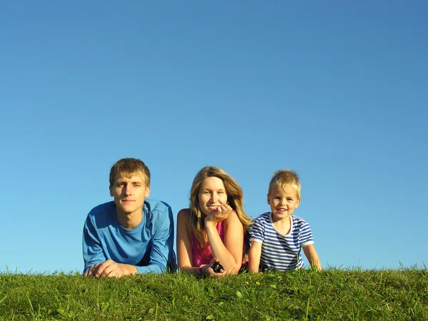 Familia sobre hierba bajo cielo azul — Foto de Stock