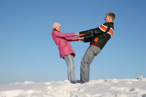 Пара, держащаяся за руки на снегу — стоковое фото