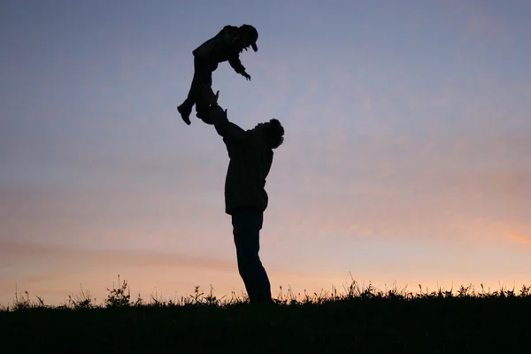 Silhouette padre con bambino — Foto Stock