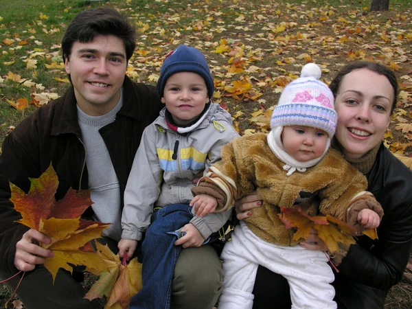 Лица семьи из четырех человек на кленовых листьях — стоковое фото