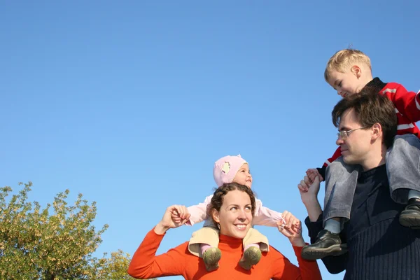 Family with children on shoulders — Zdjęcie stockowe