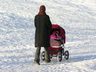 Mother with baby carriage. winter clipart
