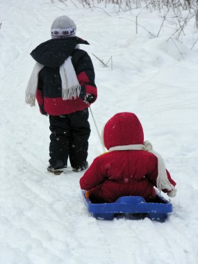 Child with baby on sled clipart