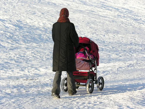 Mother with baby carriage. winter — Stock Photo, Image