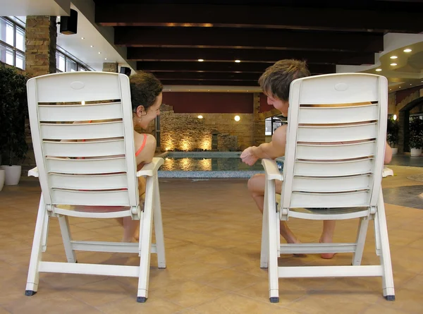Dietro coppia su sedie e piscina — Foto Stock