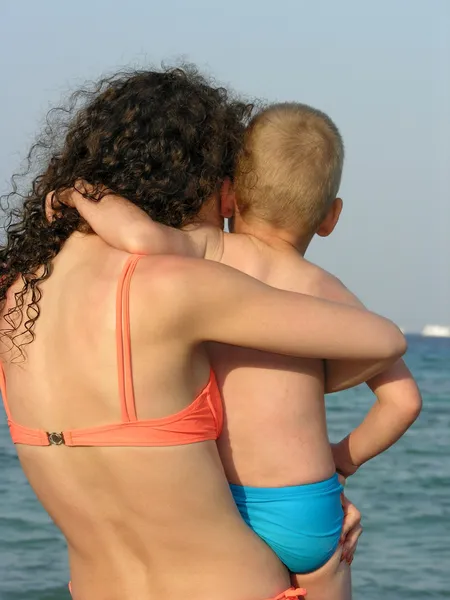 Дитина на руках матері. Назад .море . — стокове фото