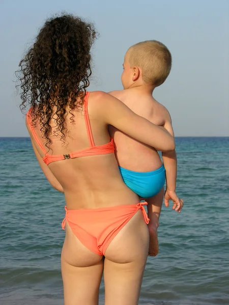 Bakom mor med pojke på stranden — Stockfoto