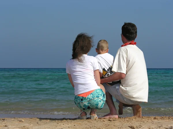 Za rodziny chłopca na plaży — Zdjęcie stockowe