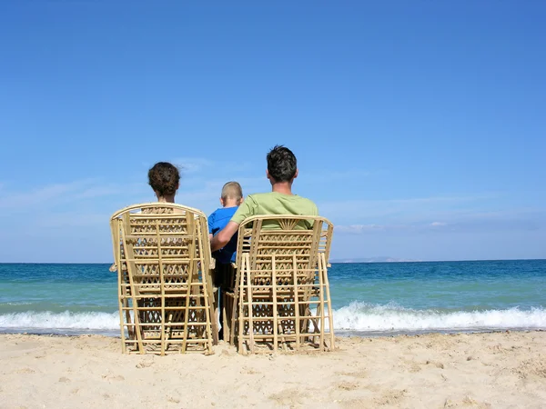Achter familie op easychairs op strand — Stockfoto