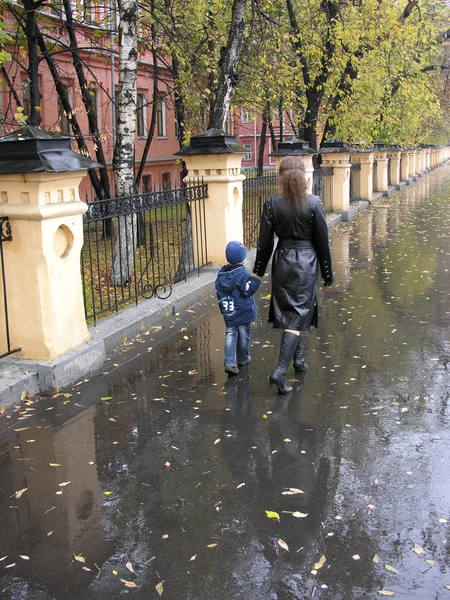 母亲与儿子步行。秋天。雨 — 图库照片