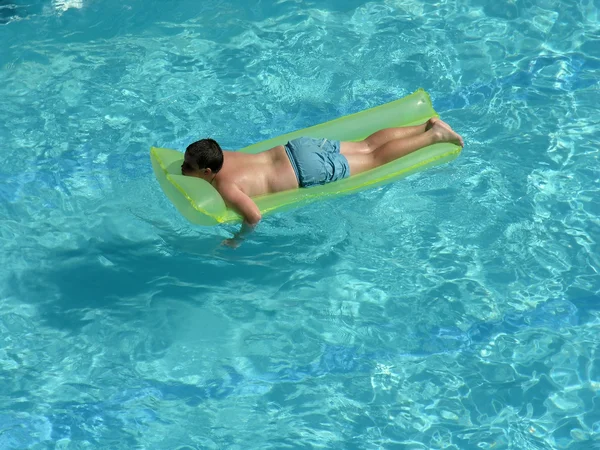 Junge auf Matratze im Pool — Stockfoto