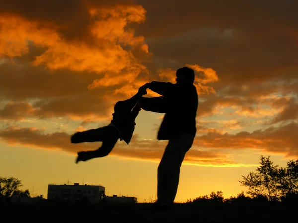 Vader roteren zoon zonsondergang — Stockfoto