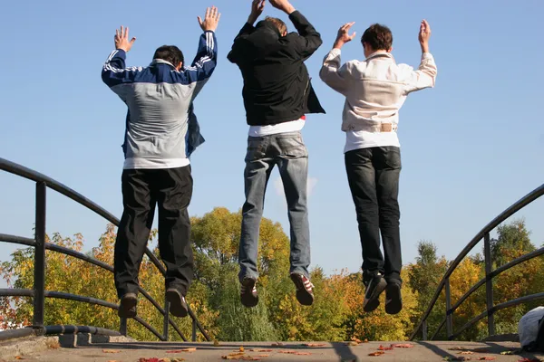 Saltare i ragazzi sul ponte autunnale — Foto Stock