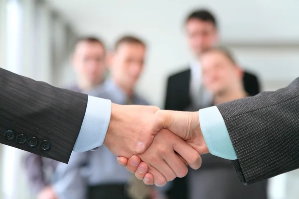 Shaking hands with wrists and business team — Stock Photo, Image