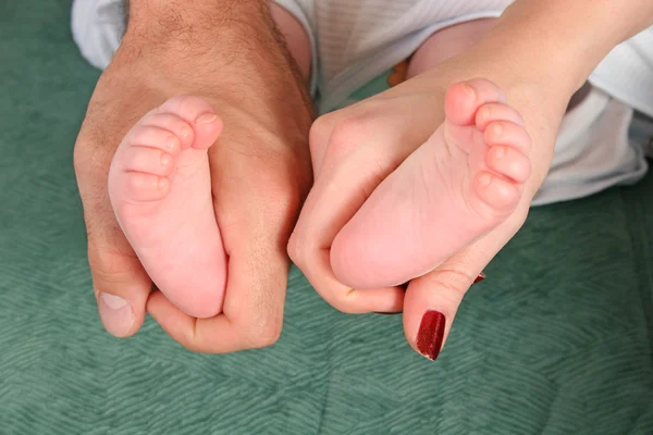 Pais mãos com pernas de bebê — Fotografia de Stock