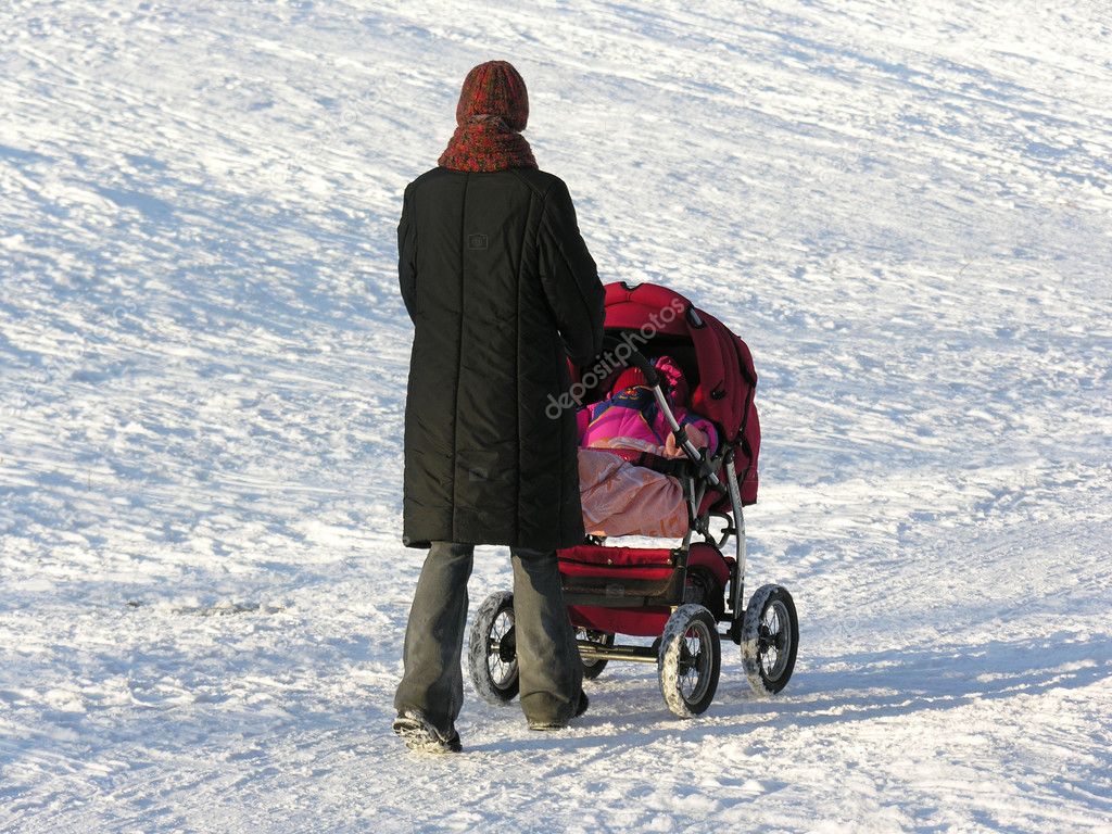 Mother with baby carriage. winter