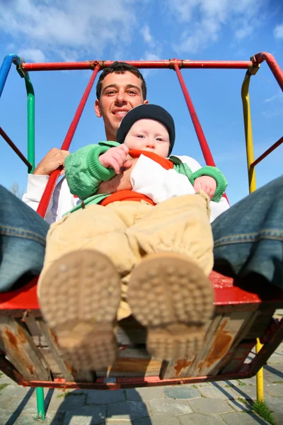 Father with baby on seesaw — Stock Photo, Image