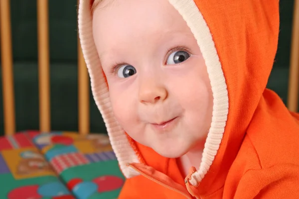 Bir gülümseme ile kukuleta erkek bebek — Stok fotoğraf