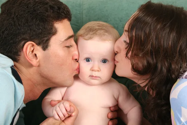 Родители целуют ребенка — стоковое фото
