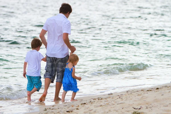 Padre con dos hijos caminando por la playa — Foto de Stock