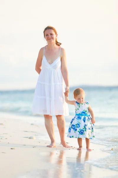 Mãe e filha na praia tropical ao pôr do sol — Fotografia de Stock